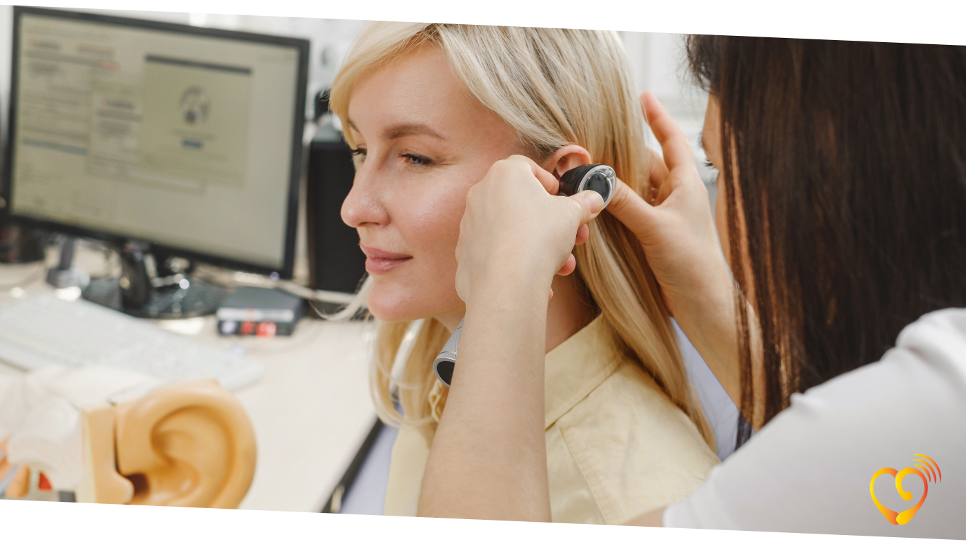 Fonoaudiologa realizando um ajuste no aparelho auditivo Fonoaudiologa realizando um ajuste no aparelho auditivo